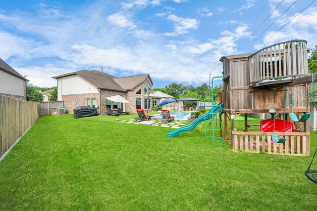 view of yard with a playground, a pool, and a patio area
