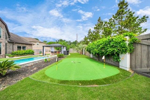 fenced backyard with a gazebo and an area to practice putting