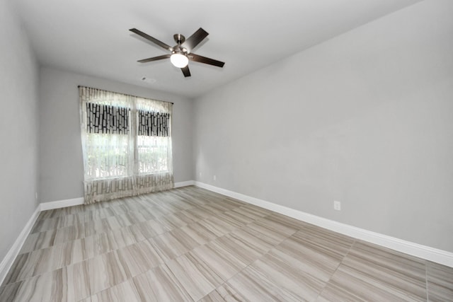 spare room with ceiling fan, baseboards, and tile patterned flooring