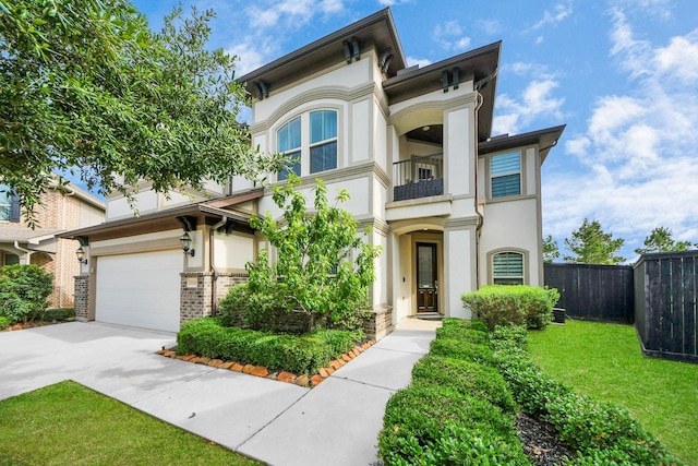 view of front of home with a balcony, concrete driveway, and stucco siding