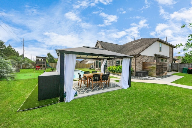 rear view of house with a gazebo, a patio area, a playground, and brick siding
