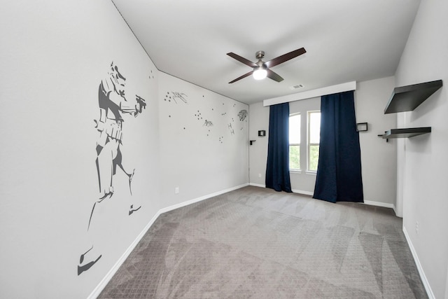 carpeted empty room with ceiling fan and baseboards