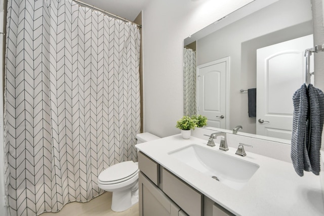 bathroom with toilet, vanity, and a shower with shower curtain
