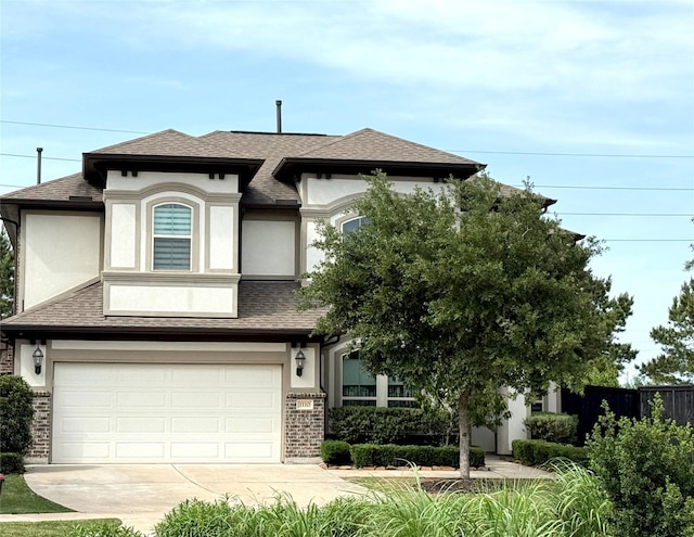 view of front of home featuring stucco siding, driveway, an attached garage, roof with shingles, and brick siding