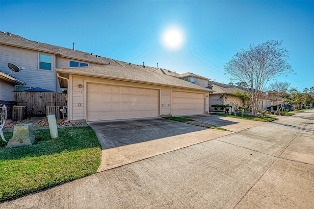 9154 Sunlight Oak Ln, Houston, TX 77070 - view of front facade with fence, an attached garage, driveway, and central AC unit