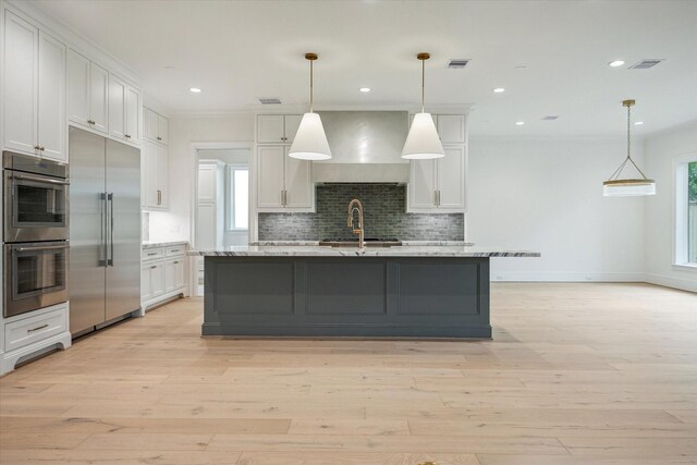 1016 Alexander St, Houston, TX 77008 - kitchen featuring appliances with stainless steel finishes, wall chimney exhaust hood, backsplash, white cabinets, and crown molding