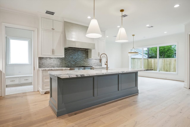 1016 Alexander St, Houston, TX 77008 - kitchen featuring premium range hood, a sink, white cabinetry, light stone counters, and backsplash