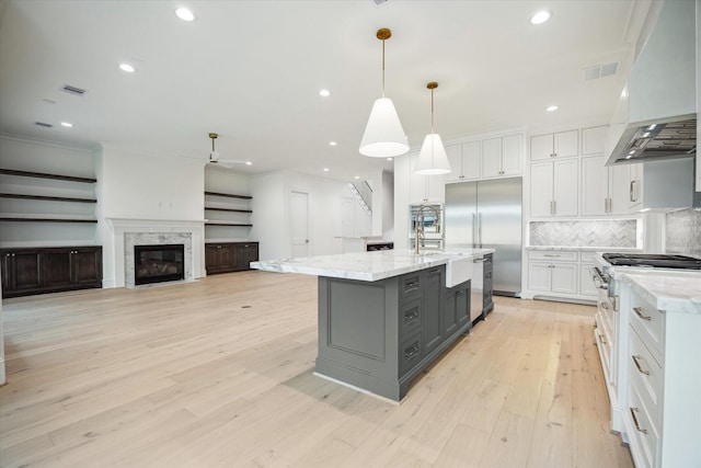 1016 Alexander St, Houston, TX 77008 - kitchen with gray cabinets, white cabinets, custom exhaust hood, built in fridge, and ornamental molding
