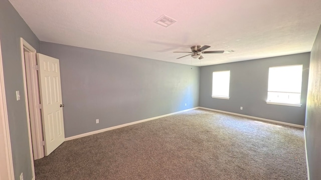 empty room with visible vents, carpet, ceiling fan, and baseboards