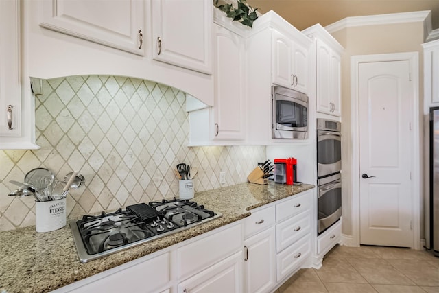 2402 Chesley Park Ct, Katy, TX 77494 - kitchen with stainless steel appliances, white cabinetry, tasteful backsplash, and light stone counters