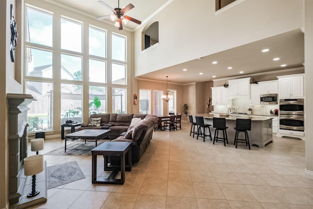 2402 Chesley Park Ct, Katy, TX 77494 - living area featuring ceiling fan, crown molding, light tile patterned flooring, a towering ceiling, and a chandelier