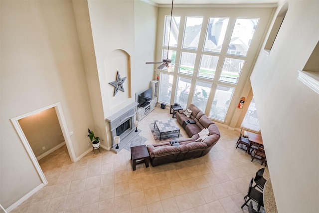 2402 Chesley Park Ct, Katy, TX 77494 - living area with a high ceiling, a ceiling fan, light tile patterned floors, baseboards, and a fireplace