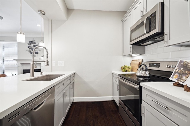 1201 Mcduffie St Unit 169, Houston, TX 77019 - kitchen with appliances with stainless steel finishes, a sink, baseboards, dark wood-style floors, and tasteful backsplash