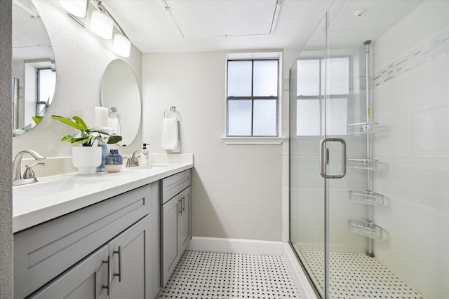 1201 Mcduffie St Unit 169, Houston, TX 77019 - bathroom featuring tile patterned floors, a stall shower, double vanity, and baseboards