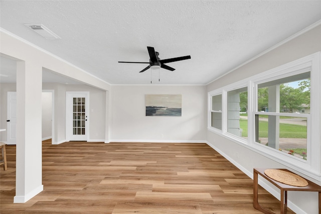 409 24th Ave N, Texas City, TX 77590 - unfurnished living room with light wood-style floors, a ceiling fan, a textured ceiling, and crown molding