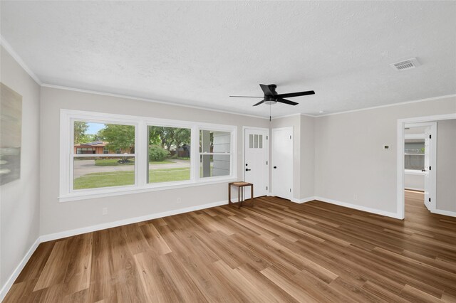 409 24th Ave N, Texas City, TX 77590 - unfurnished living room with wood finished floors, ceiling fan, a textured ceiling, and ornamental molding