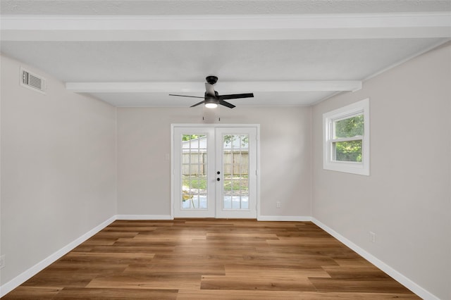 409 24th Ave N, Texas City, TX 77590 - unfurnished room featuring french doors, healthy amount of natural light, beamed ceiling, ceiling fan, and wood finished floors