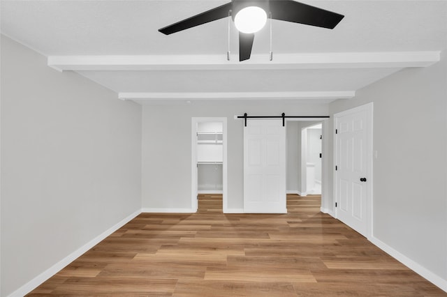409 24th Ave N, Texas City, TX 77590 - unfurnished bedroom featuring beam ceiling, a spacious closet, light wood finished floors, a closet, and ceiling fan