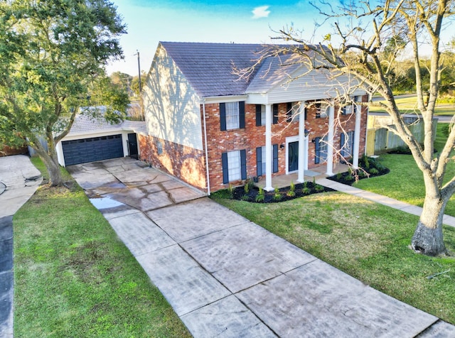 neoclassical home featuring a shingled roof, brick siding, a garage, a front yard, and driveway