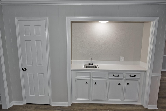 bathroom with a sink, baseboards, and wood finished floors