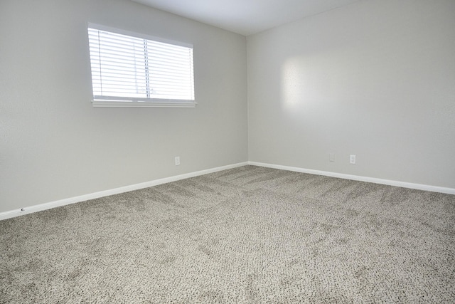 unfurnished room with baseboards and carpet