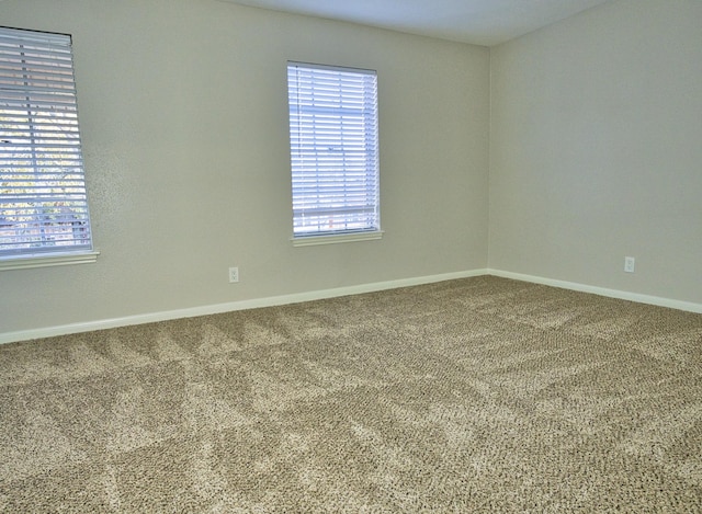 carpeted spare room with baseboards