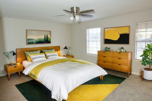 bedroom with baseboards, carpet flooring, a ceiling fan, and multiple windows
