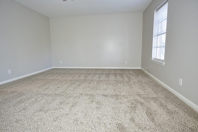 spare room featuring baseboards and carpet flooring