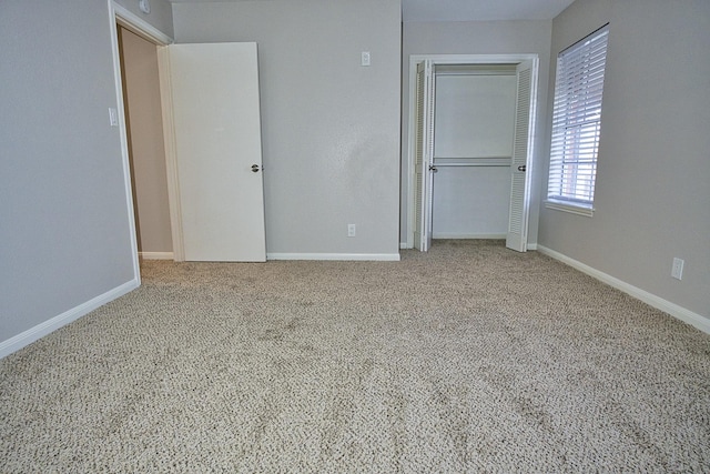 unfurnished bedroom with carpet floors, baseboards, and a closet
