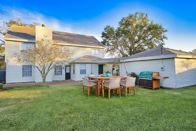back of house featuring a yard and a chimney