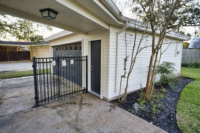 property entrance featuring a garage, fence, and a gate