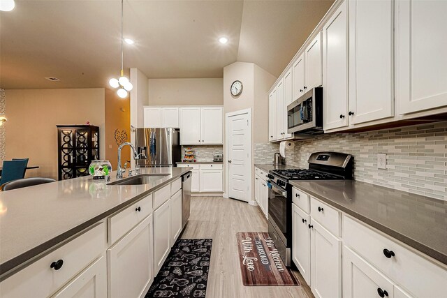 4723 Great Acre Ln, Fresno, TX 77545 - kitchen featuring decorative backsplash, appliances with stainless steel finishes, a sink, white cabinets, and light wood-style floors