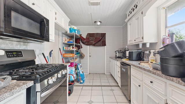 kitchen featuring tasteful backsplash, stainless steel appliances, white cabinetry, and visible vents