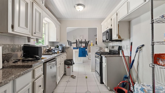 kitchen featuring ornamental molding, light tile patterned flooring, white cabinets, tasteful backsplash, and appliances with stainless steel finishes