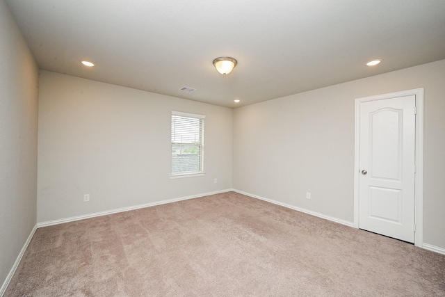 carpeted spare room featuring recessed lighting, baseboards, and visible vents