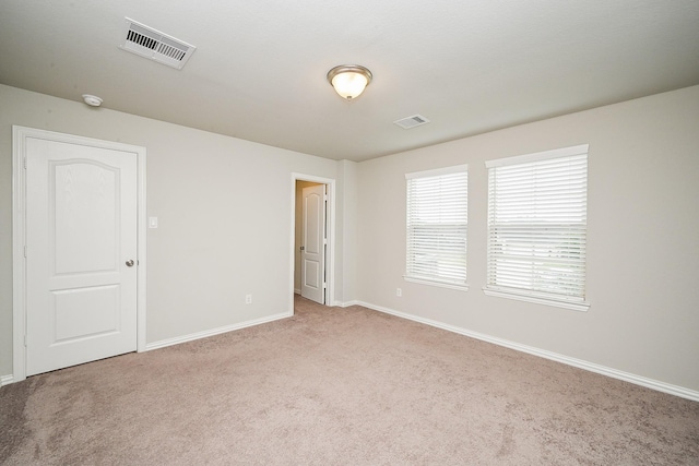 spare room with visible vents, carpet, and baseboards