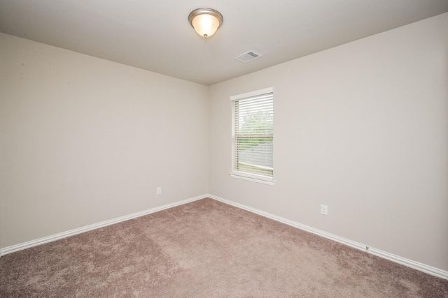 carpeted empty room featuring baseboards and visible vents