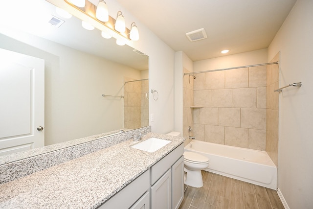 bathroom featuring visible vents, wood finished floors, toilet, and vanity