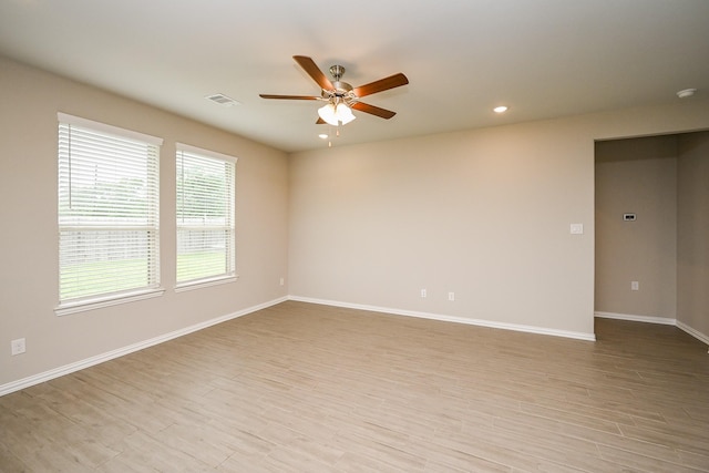 unfurnished room with a ceiling fan, visible vents, light wood-type flooring, baseboards, and recessed lighting