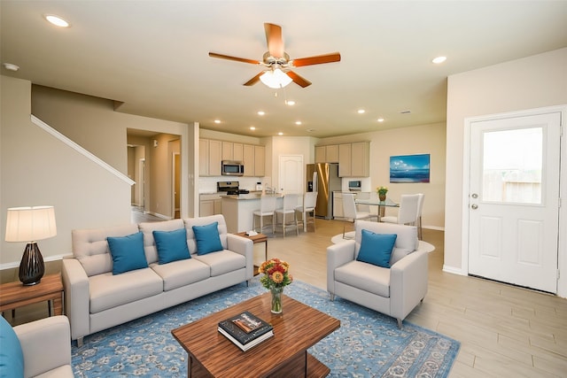 living area with recessed lighting, ceiling fan, baseboards, and light wood finished floors