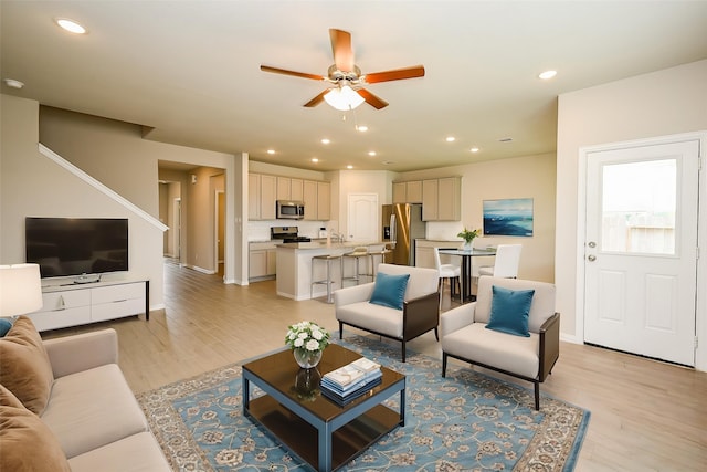 living area with recessed lighting, ceiling fan, baseboards, and light wood-type flooring