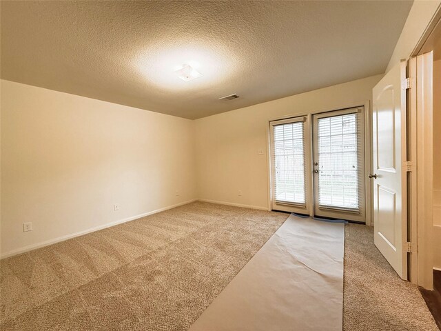 2093 Saras Way, Brookshire, TX 77423 - spare room featuring baseboards, visible vents, a textured ceiling, and light colored carpet
