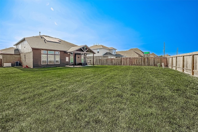 view of yard with central AC unit, a fenced backyard, and a patio area