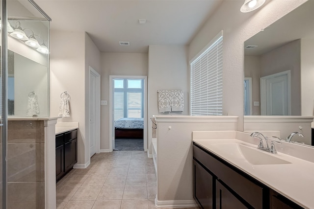 bathroom featuring visible vents, baseboards, ensuite bathroom, tile patterned floors, and a sink