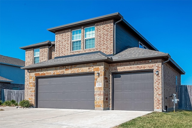 traditional home with a garage, fence, brick siding, a shingled roof, and driveway