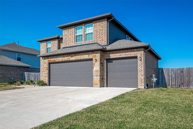 traditional home with an attached garage, fence, driveway, and a front yard