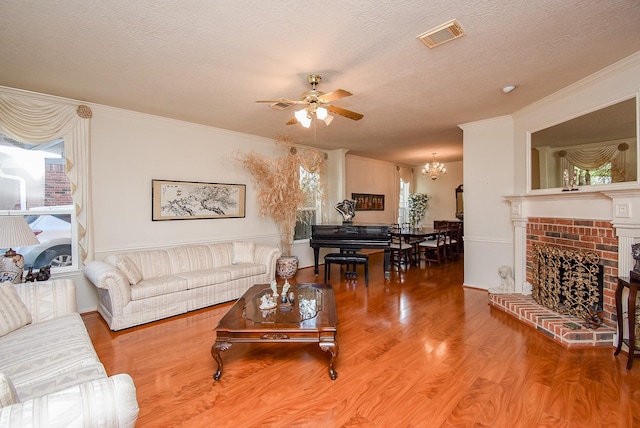 9706 Garden Row Dr, Sugar Land, TX 77498 - living area featuring a textured ceiling, visible vents, wood finished floors, ceiling fan with notable chandelier, and ornamental molding