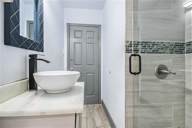full bath with vanity, wood finished floors, and a shower stall