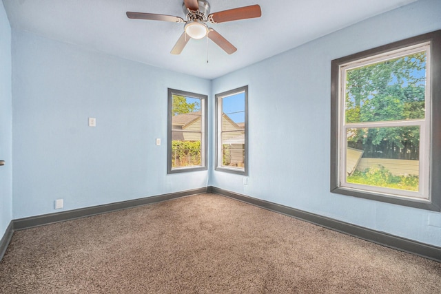 empty room with baseboards, ceiling fan, and carpet