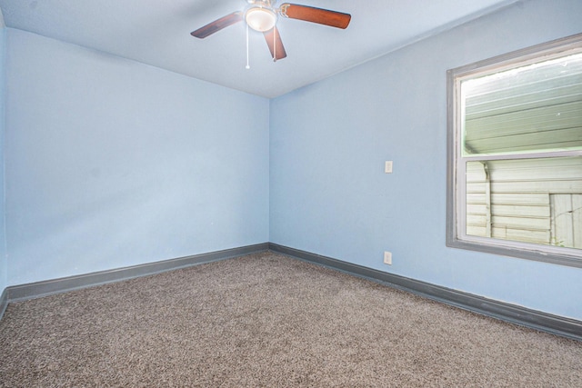 spare room with carpet floors, a ceiling fan, and baseboards
